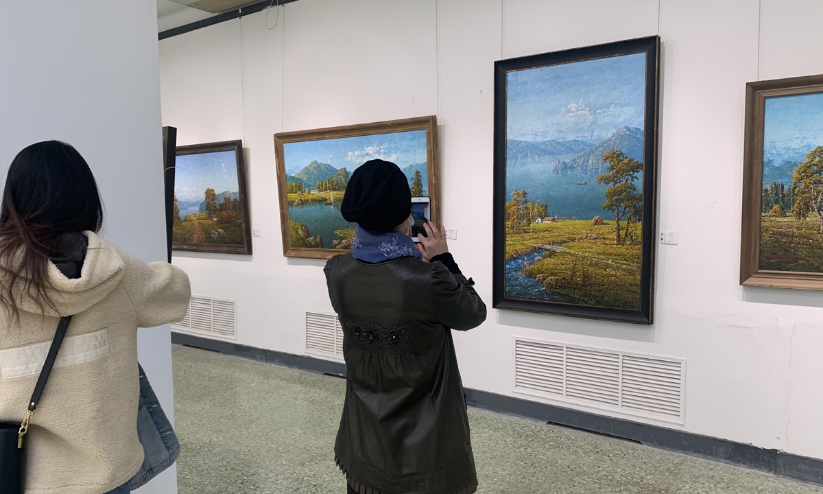 Chinese visitors take photos of North Korean oil paintings. Photo: Courtesy of Gu Xinxia