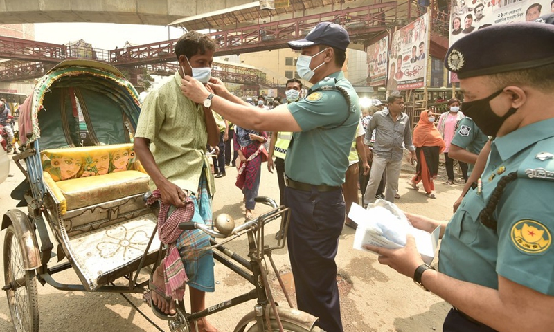 Law enforcers distribute masks in Dhaka, Bangladesh on March 21, 2021.(Photo: Xinhua)