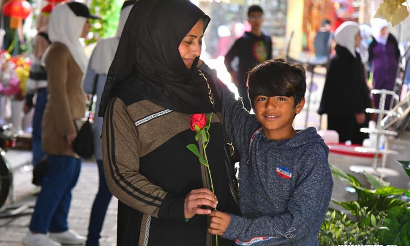 A boy gives his mother a flower on the occasion of Syrian Mother's Day in Damascus, Syria, on March 21, 2021.(Photo: Xinhua)
