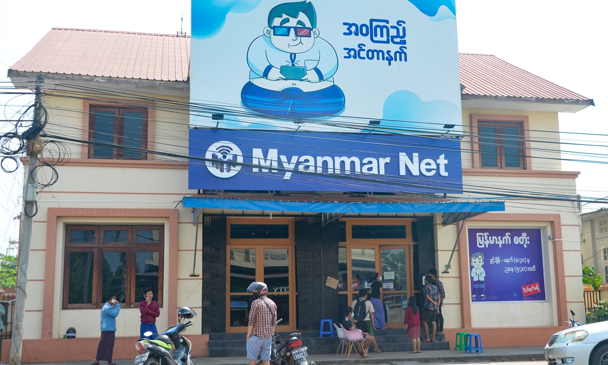 People wait outside an internet shop to check the connection and Facebook in Naypyidaw on March 16, 2021, as Myanmar authorities ordered telecommunication companies to restrict their services on the mobile data networks. Photo: VCG