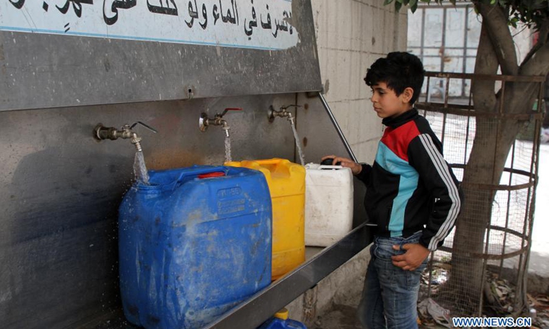 A Palestinian child fills buckets with water at the Shati refugee camp in Gaza City, on March 22, 2021. Palestinian President Mahmoud Abbas called on the international donors on Monday to continue their support for the central water station in the Gaza Strip to help end the water crisis in the besieged Palestinian enclave.(Photo: Xinhua)