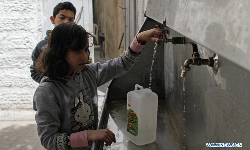 A Palestinian child fills a bucket with water at the Shati refugee camp in Gaza City, on March 22, 2021. Palestinian President Mahmoud Abbas called on the international donors on Monday to continue their support for the central water station in the Gaza Strip to help end the water crisis in the besieged Palestinian enclave.(Photo: Xinhua)