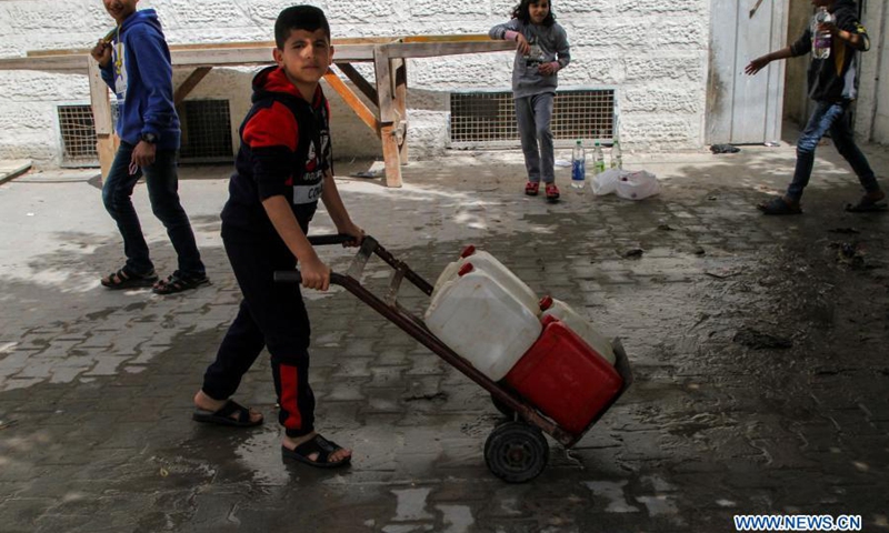 A Palestinian child pushes a cart with buckets of water at the Shati refugee camp in Gaza City, on March 22, 2021. Palestinian President Mahmoud Abbas called on the international donors on Monday to continue their support for the central water station in the Gaza Strip to help end the water crisis in the besieged Palestinian enclave.(Photo: Xinhua)