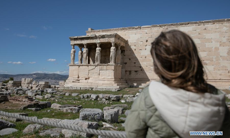 A woman visits the archeological site of Acropolis in Athens, Greece, on March 22, 2021. On Monday, open-air archeological sites, including the Acropolis hill in Athens, reopened for the first time since the start of the lockdown. Only a small group of visitors is allowed to visit and the use of protective face masks is obligatory.(Photo: Xinhua)