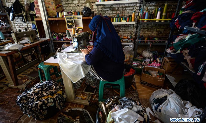 A worker wearing a face mask sews clothes at the NCK Textile home factory at Curug village in Bogor, West Java, Indonesia, on March 23, 2021. NCK Textile produces clothes to orders from local markets, and provides job opportunities to people in its neighborhood.(Photo: Xinhua)