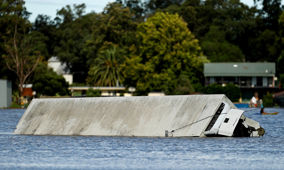A truck trailer submerged in flood water in the suburb of McGraths Hill in Sydney, Australia, on Wednesday, March 24, 2021. Photo: VCG
