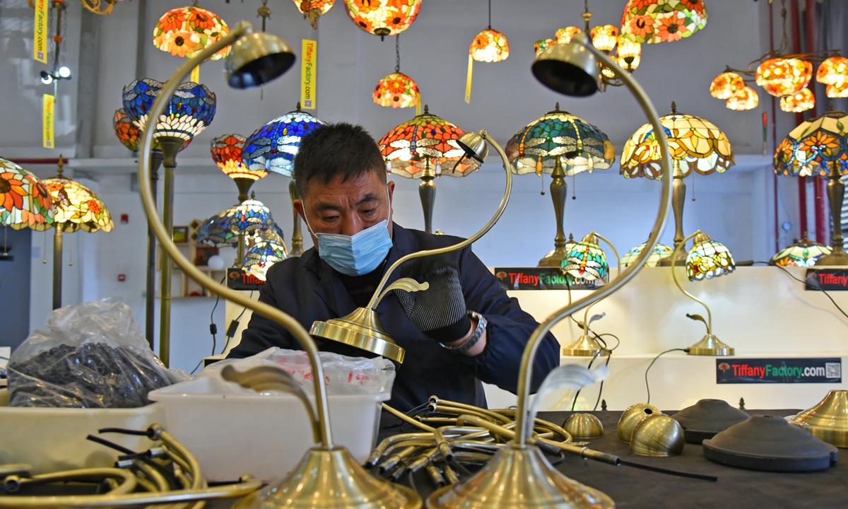 A worker assembles colorful glass lamps on Wednesday in an electronic information industrial park in Lianyungang, East China's Jiangsu Province. The lamps will be sold via cross-border e-commerce platforms to Europe, the US, Japan and Australia. The city has encouraged local manufacturers to give up producing on behalf of foreign companies, urging them to establish their own export-oriented brands. Photo: cnsphoto