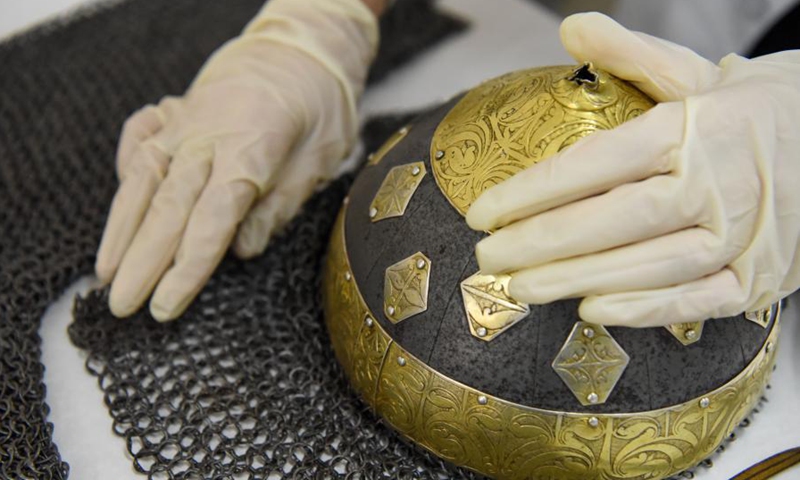 A staff member arranges the restored chain mail at the Museum of Xinjiang Uygur Autonomous Region in Urumqi, northwest China's Xinjang Uygur Autonomous Region, March 19, 2021. Northwest China's Xinjiang Uygur Autonomous Region has restored 118 prominent antique items under five restoration projects lasting three years. (Xinhua)