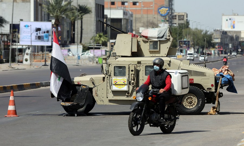 A delivery worker passes a mobile checkpoint set up as part of the restrictive measures to curb the spread of COVID-19 in Baghdad, Iraq, on March 19, 2021.(Photo: Xinhua)