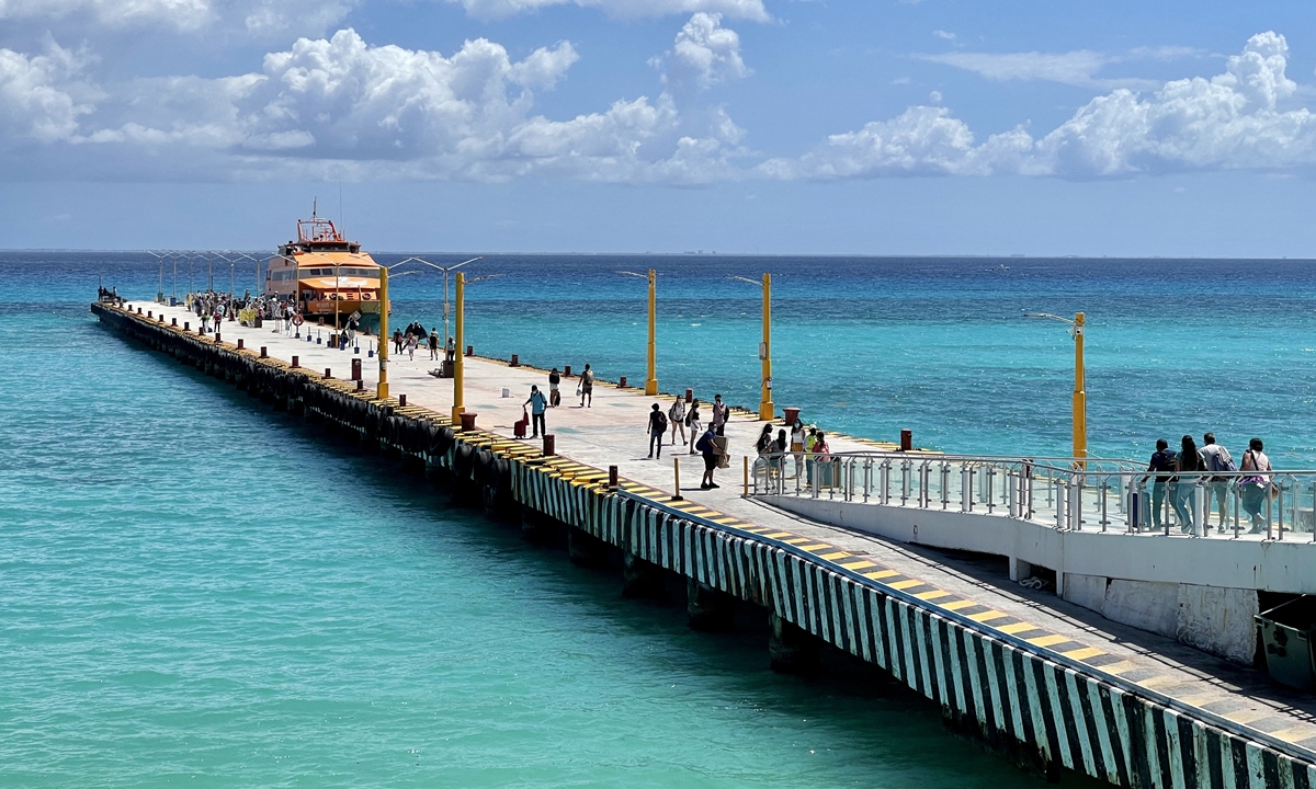Tourists walk at a pier to get on a boat to Cozumel Island, in Playa del Carmen, Mexico on March 3. Photo: AFP 