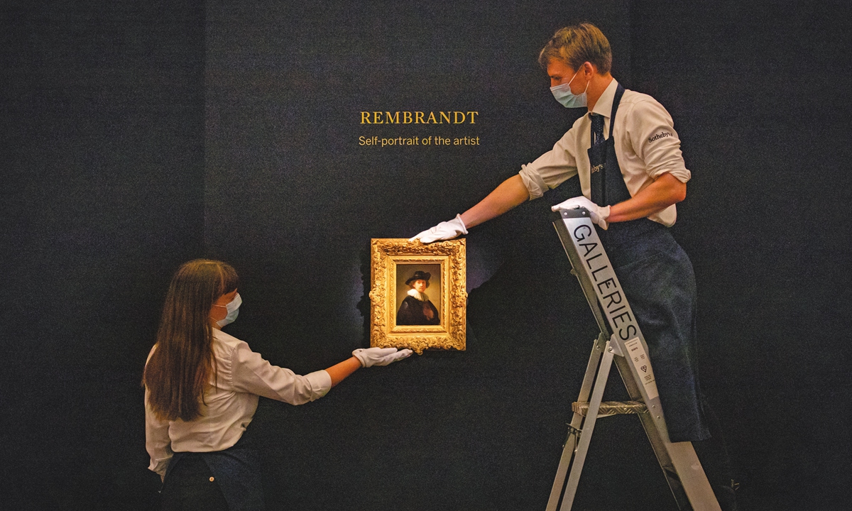 Gallery assistants hang Self-portrait, wearing a ruff and black hat by Rembrandt during a press preview at Sotheby's in London ahead of their From Rembrandt to Richter sale on July 28, 2020. Photo: VCG