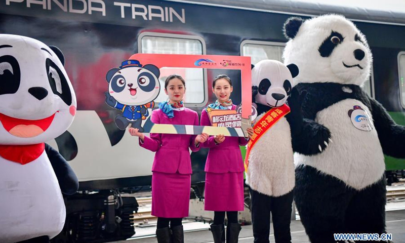 Stewardesses pose in front of the panda train in southwest China's Sichuan Province, March 24, 2021. China's first panda-themed tourist train panda train started trial run in Sichuan on Wednesday and will start operation on March 28. Transformed from a normal train, the panda train features upgraded standards inclucing 5G wireless network coverage, music and video entertainment system, restaurant and bar, chess and card room and private toilets with constant temperature shower in sleeping carriages.(Photo: Xinhua)