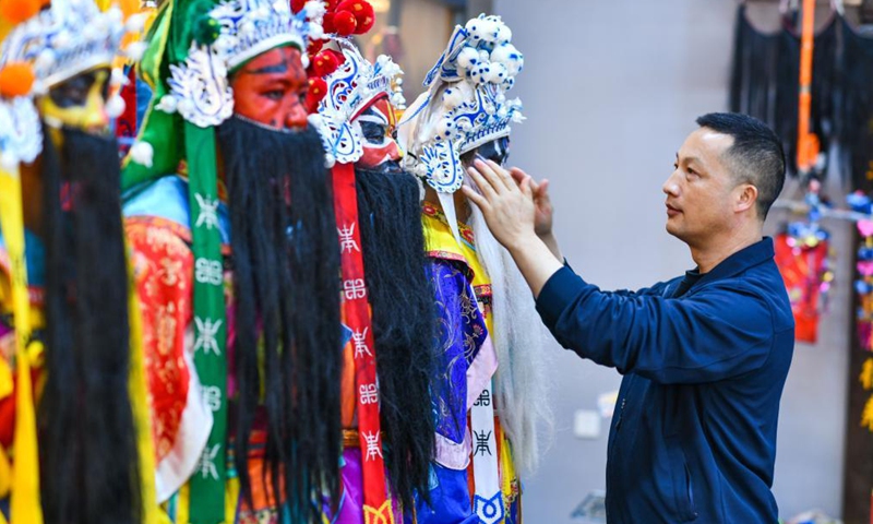 Inheritor Liu Jiang (1st R) helps a student get prepared at the No. 3 Middle School of Longli County, Qiannan Buyi and Miao Autonomous Prefecture, southwest China's Guizhou Province, March 23, 2021. In order to pass on and protect the traditional opera Taiping Huadengxi of Longli County, the No. 3 Middle School of Longli County has invited inheritors of the opera to give regular lessons to students.(Xinhua)