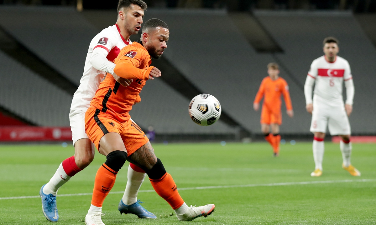 Zeki Celik (left) of Turkey and Memphis Depay of the Netherlands compete for the ball during their World Cup qualifier match at the Ataturk Olympic Stadium on Wednesday in Istanbul, Turkey. Photo: VCG