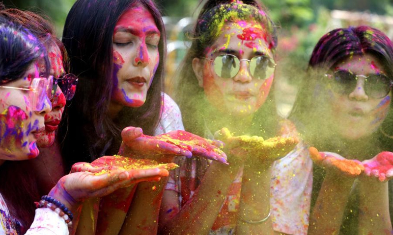 indian people have their faces smeared with colored powder