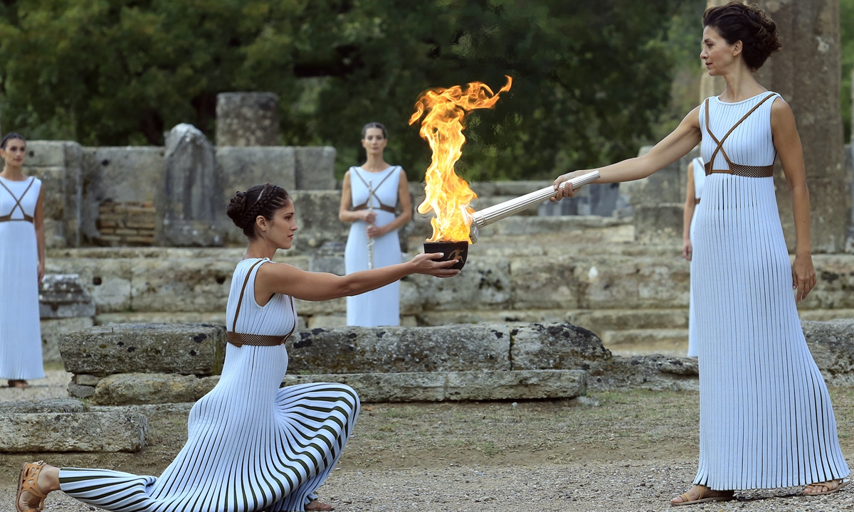 High priestess passes the Olympic flame during a lighting ceremony of the Olympic flame in ancient Olympia on October 24, 2017. Photo: VCG