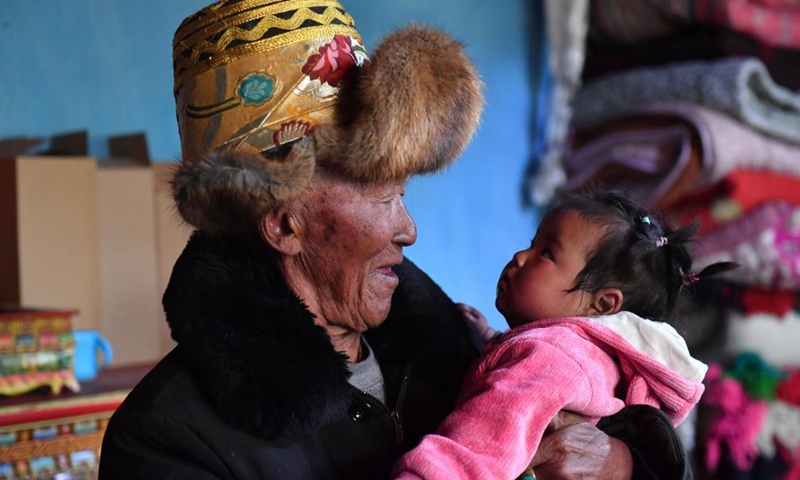 Basang holds his 9-month-old great-granddaughter at his home in Taye Village of Xigaze, southwest China's Tibet Autonomous Region, March 21, 2021. Basang, born in 1934, is a villager of Taye Village in Xigaze, China's Tibet Autonomous Region. In the old times, the family of Basang had to pay various taxes to serf owners, which made the family lead a miserable life. (Photo:Xinhua)