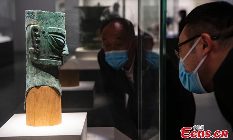 Two visitors observe an ancient bronze figure statue unearthed from the Sanxingdui Ruins at the National Museum of China in Beijing, March 26, 2021. The shock of hundreds of more than 3,000-year-old cultural relics newly excavated from the Sanxingdui Ruins site in SW China’s Sichuan continues across China. Some stunning discoveries from the Sanxingdui Ruins preserved at the National Museum of China has drawn a number of visitors.  Photo: China News Service