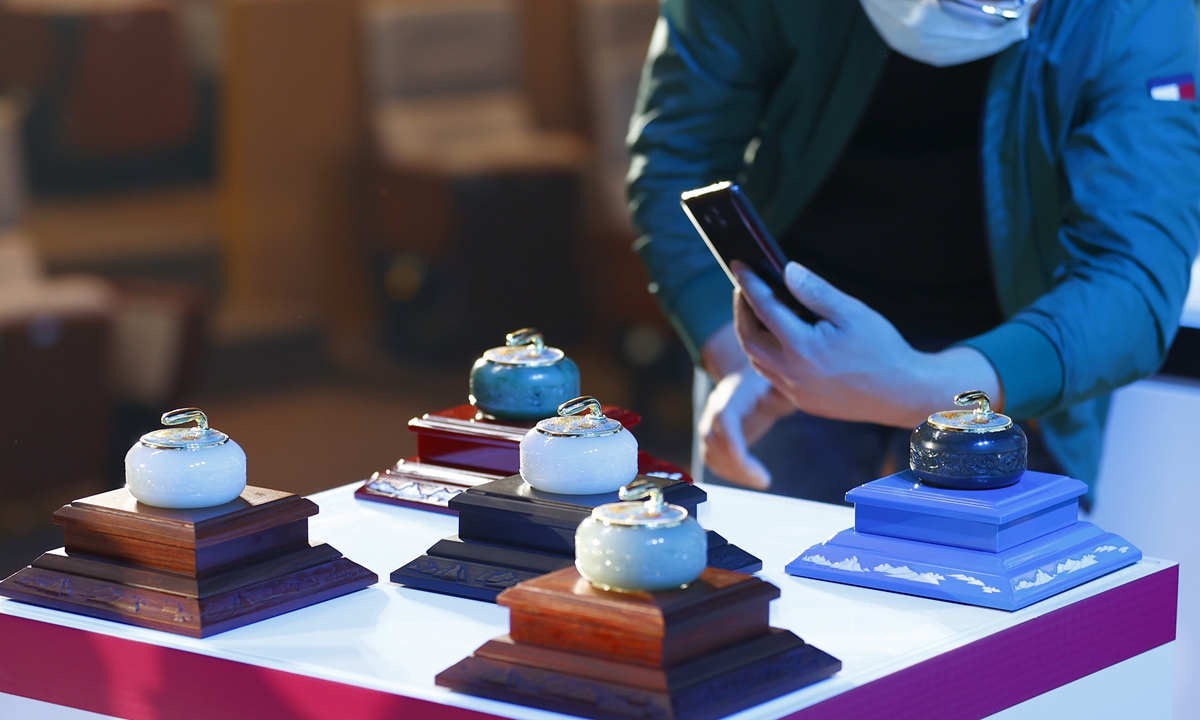 A man inspects pots made by Hetian jade on Friday. The pots, made of cloisonné and jade carving, are Beijing Winter Olympics licensed products. Preparations for the Games are on track about a year away. Photo: VCG