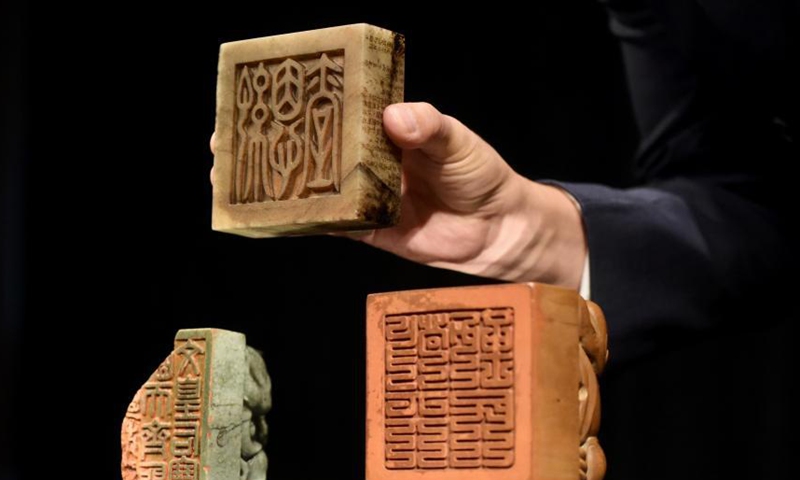 Three Imperial seals of the Ming and Qing Dynasties are presented by a staff member of Sotheby’s Hong Kong office, March 25, 2021.  Photo: China News Service