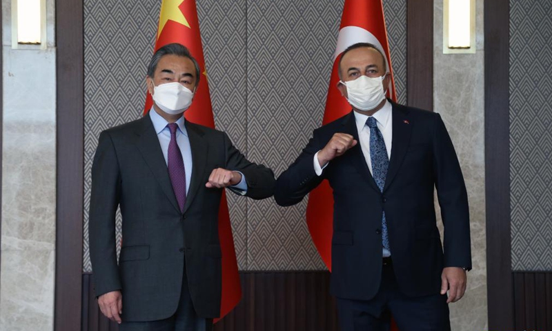 Visiting Chinese State Councilor and Foreign Minister Wang Yi (L) touches elbows with Turkish Foreign Minister Mevlut Cavusoglu during their meeting in Ankara, Turkey, on March 25, 2021.Photo:Xinhua