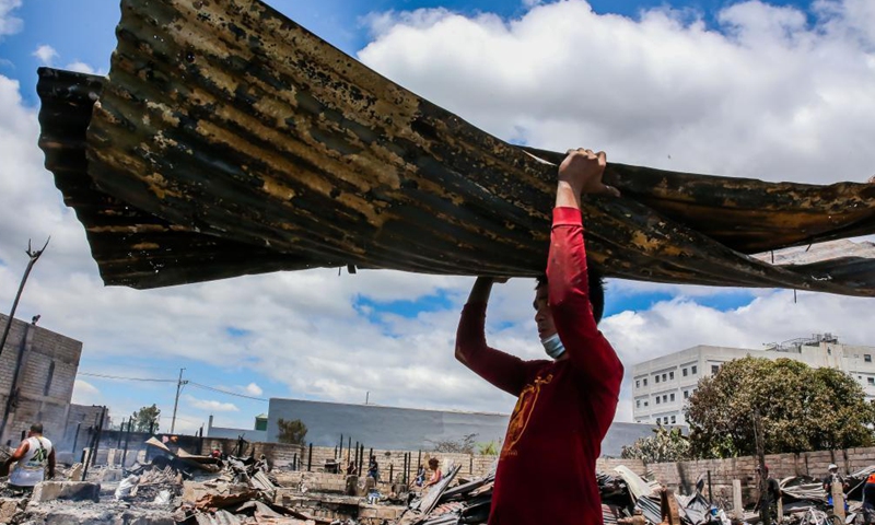 Residents search for their belongings from their charred homes after a fire at a slum area in Rizal Province, the Philippines on March 26, 2021. The Philippine Bureau of Fire Protection said that the fire is believed to have started from one of the houses that was being used as a garment manufacturing area, leaving more than 170 families homeless in the fire.Photo:Xinhua