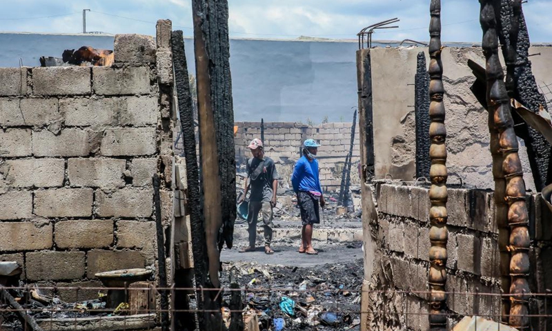 Residents search for their belongings from their charred homes after a fire at a slum area in Rizal Province, the Philippines on March 26, 2021. The Philippine Bureau of Fire Protection said that the fire is believed to have started from one of the houses that was being used as a garment manufacturing area, leaving more than 170 families homeless in the fire.Photo:Xinhua