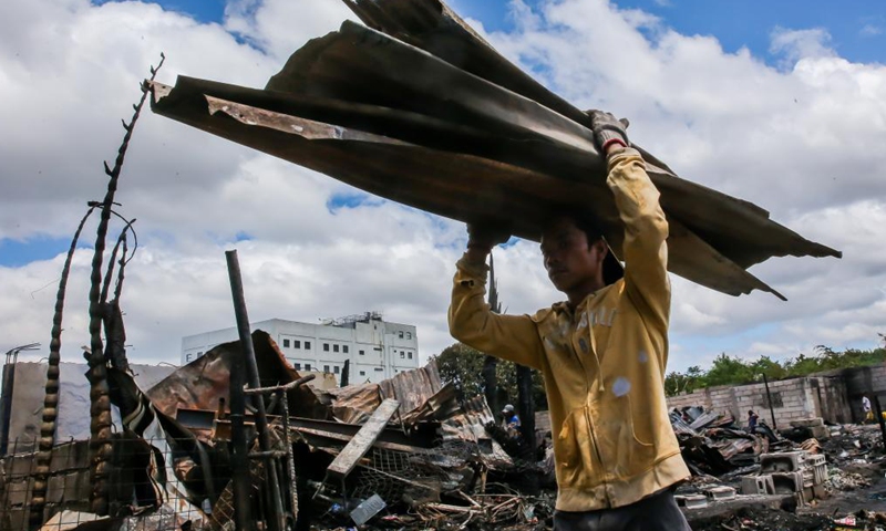 Residents search for their belongings from their charred homes after a fire at a slum area in Rizal Province, the Philippines on March 26, 2021. The Philippine Bureau of Fire Protection said that the fire is believed to have started from one of the houses that was being used as a garment manufacturing area, leaving more than 170 families homeless in the fire.Photo:Xinhua