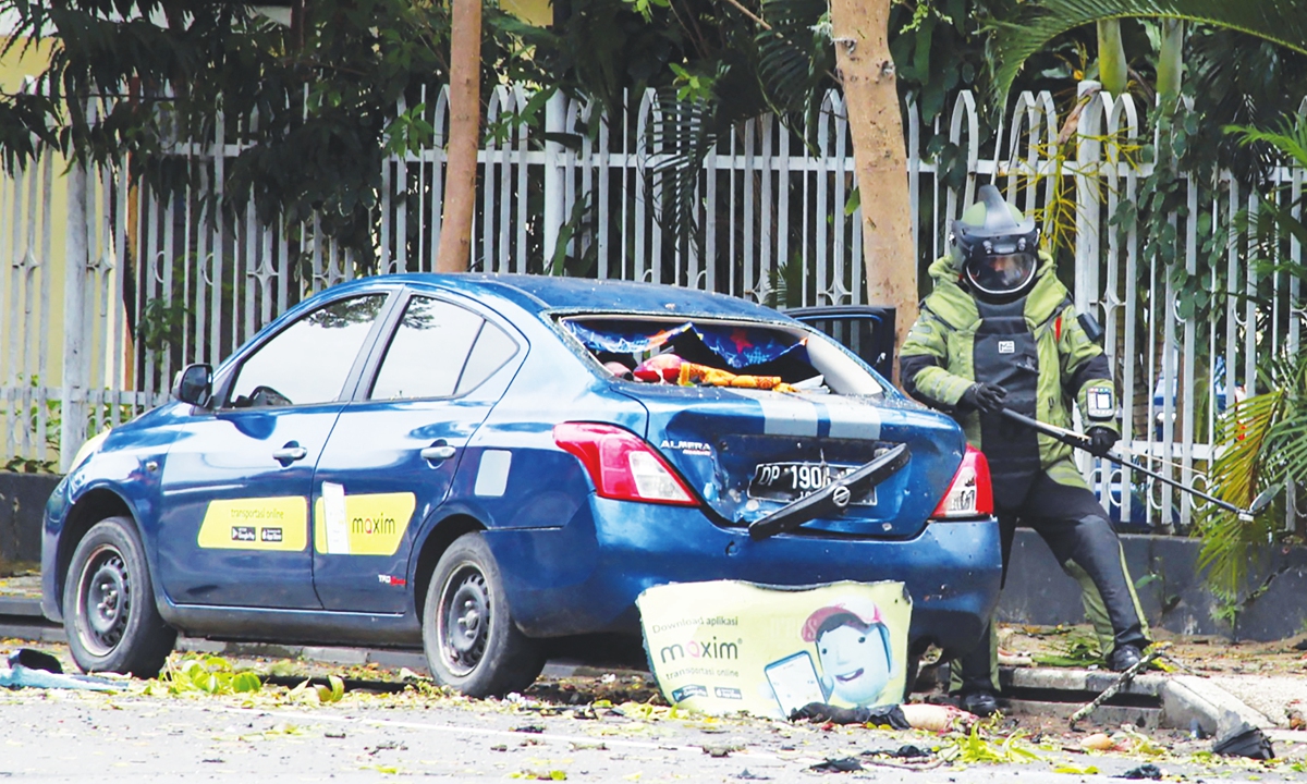 An Indonesian anti-bomb unit (center) collects evidences after a bomb detonated in Makassar, Indonesia, on Sunday. The explosion occurred outside a cathedral in the Indonesian city of Makassar on Sunday in what a priest described as a suicide attack, local media reported. Photo: AFP