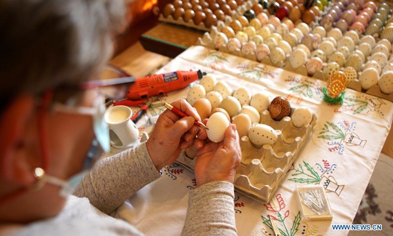 A woman paints an Easter egg in the village of Cisovice, Czech Republic, March 27, 2021. Local women in the countryside like to paint Easter eggs before the holiday and give them to others as gifts.   (Photo :Xinhua)