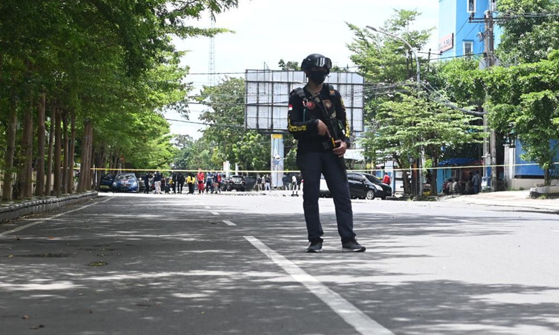 An Indonesian police officer stands guard near a Cathedral church in Makassar, South Sulawesi, Indonesia, March 28, 2021. The Indonesian police have suspected that two people committed a suicide bombing outside the Cathedral in the port city of Makassar, capital of South Sulawesi province in east Indonesia on Sunday morning, injuring at least 14 people. 