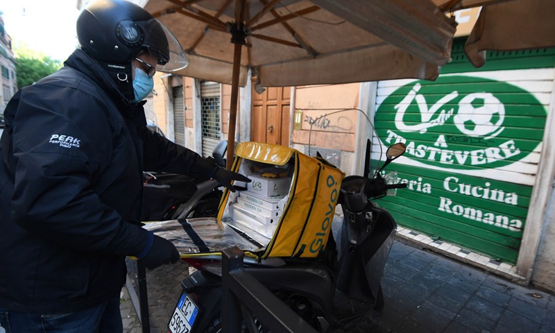 A delivery man prepares to deliver pizzas in Trastevere district in Rome, Italy, on May 2, 2020.(Photo: Xinhua)