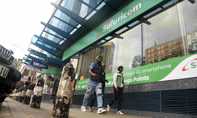 File photo shows people walk past a Safaricom Shop along a street in Nairobi, Kenya, Aug. 11, 2019. (Photo: Xinhua)