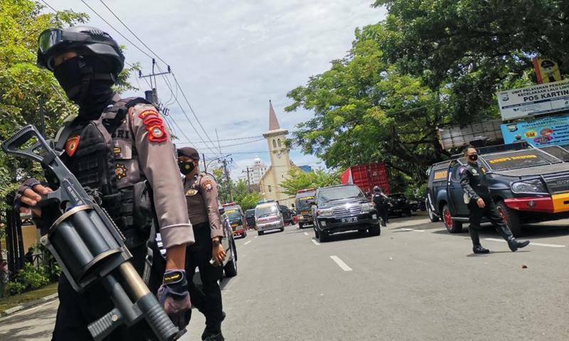 Indonesian police officers stand guard near a Cathedral church in Makassar, South Sulawesi, Indonesia, March 28, 2021. The Indonesian police have suspected that two people committed a suicide bombing outside the Cathedral in the port city of Makassar, capital of South Sulawesi province in east Indonesia on Sunday morning, injuring at least 14 people. 