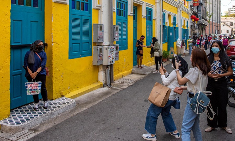 A woman wearing a face mask poses for photos on a street in Kuala Lumpur, Malaysia, March 28, 2021.(Photo: Xinhua)