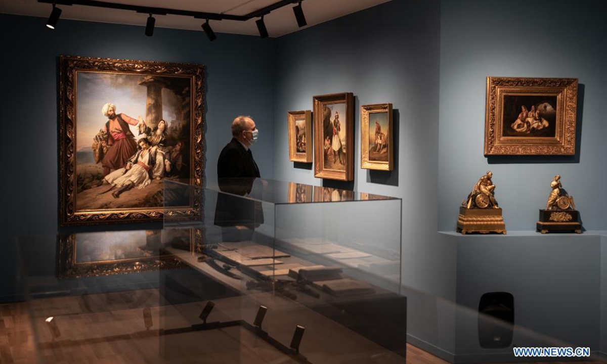Founder of Philhellenism Museum Constantinos Velentzas looks at paintings depicting episodes of the Greek War of Independence at the museum in Athens, Greece, on March 26, 2021. The newly founded Philhellenism Museum opened its door here in March, just in time for the celebration of the 200th anniversary of the start of the Greek War of Independence on Thursday. (Photo by Lefteris Partsalis/Xinhua)