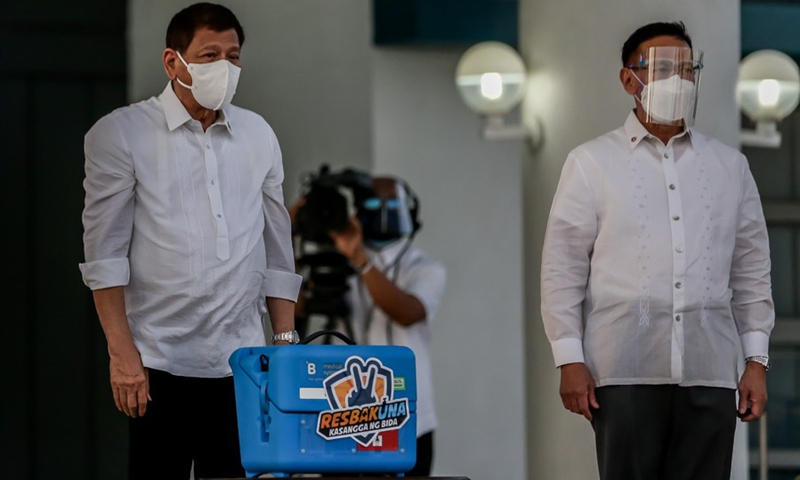 Philippine President Rodrigo Duterte (L) stands beside Health Secretary Francisco Duque as they present a case containing government-purchased Sinovac COVID-19 vaccines in Manila, the Philippines, on March 29, 2021.(Photo: Xinhua)