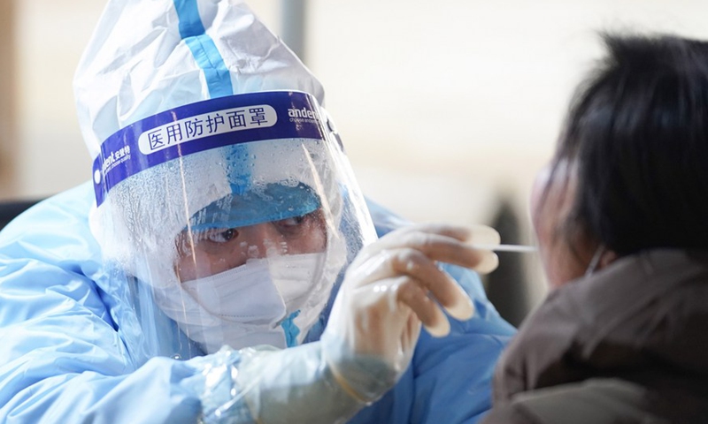 A medical worker collects a swab sample from a resident at a COVID-19 testing site in Daxing District of Beijing, capital of China, Jan. 20, 2021. (Xinhua/Ju Huanzong)