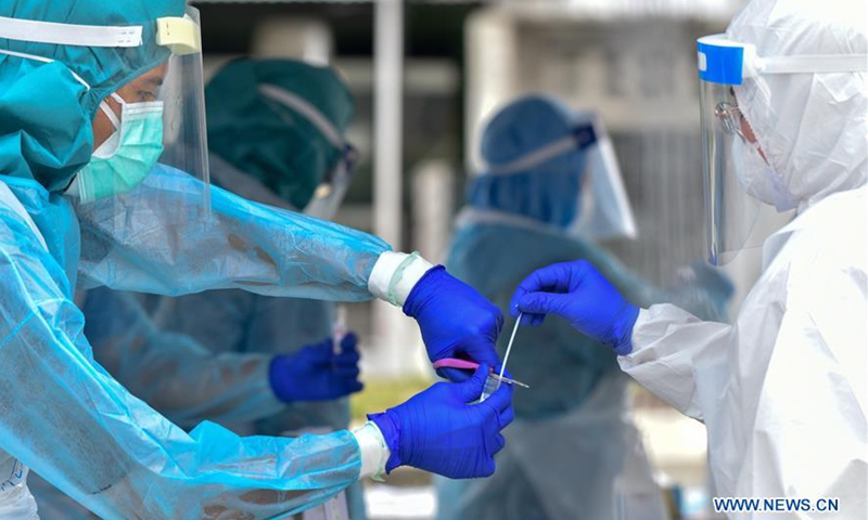 Medical staff process a swab sample collected from a resident of an area under the enhanced movement control order in Petaling Jaya, Selangor, Malaysia, May 10, 2020.File photo:Xinhua