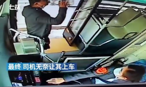 A man gulps down a bottle of baijiu after being refused to board bus. Photo: screenshot of video posted by The Paper