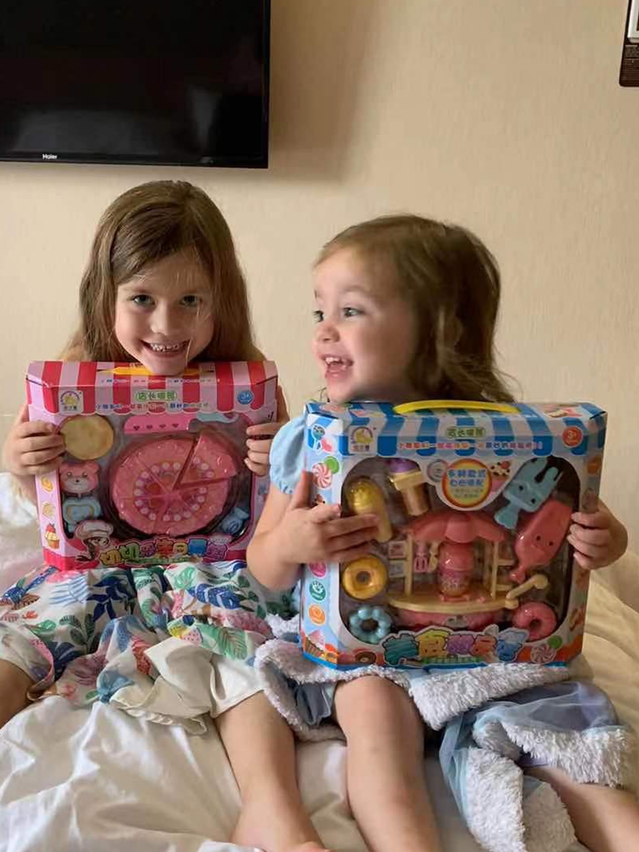 Aimee Swann's daughters holding the kids play kitchen set gifted to them by quarantine hotel in Guangzhou Photo: Courtesy of Aimee Swann