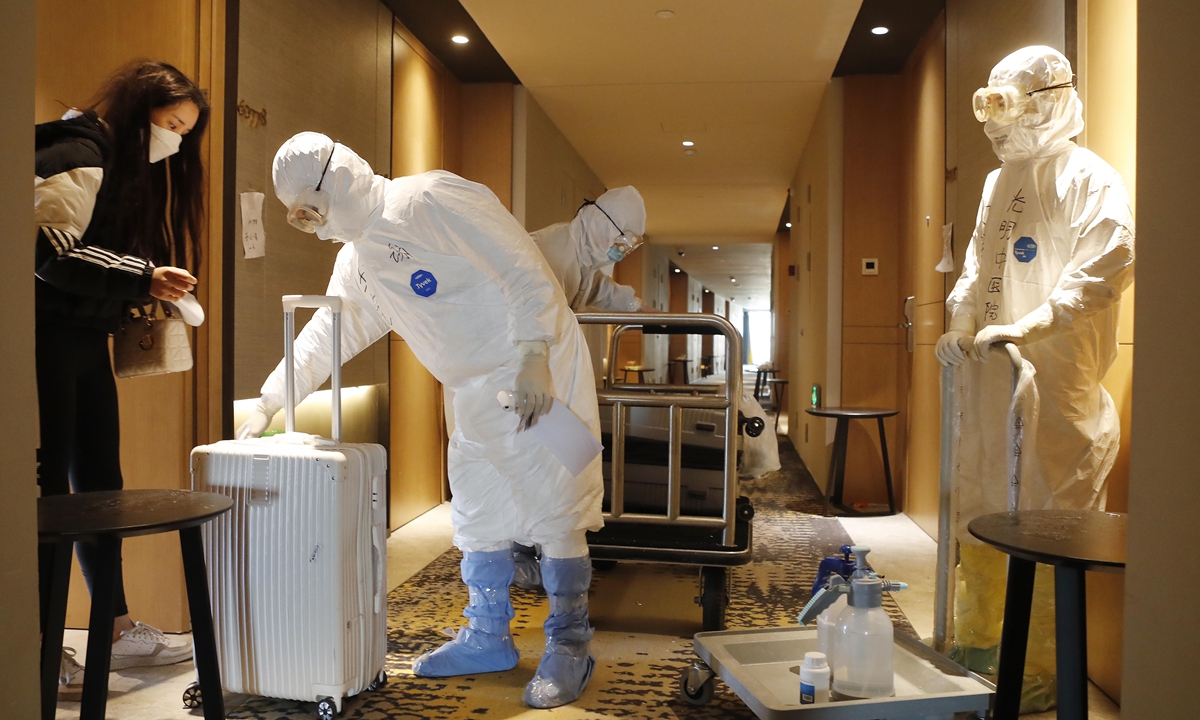 Staff disinfect the luggage of a passenger set to be released from  quarantine in a hotel in Shanghai on March 16, 2020. Photo: VCG