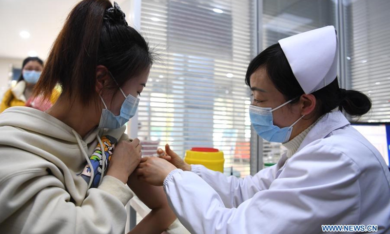 A medical worker inoculates a recipient with COVID-19 vaccine at a community health center in Feixi County of east China's Anhui Province, Jan. 20, 2021. (Photo:Xinhua)