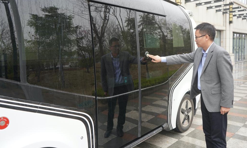 Ren Dakai, who is in charge of Xiongan digital transportation lab, opens the door of an unmanned vehicle in Xiongan New Area, north China's Hebei Province, March 26, 2021. The Xiongan digital transportation lab is committed to digital transportation research to boost smart city development.Photo:Xinhua