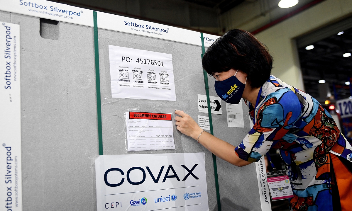 A Vietnamese Health Ministry official checks documents on a container carrying the first shipment of the AstraZeneca/Oxford COVID-19 vaccine doses, as part of the UN global ­COVAX program, as it arrives at the Noi Bai International Airport Cargo terminal in Hanoi on Thursday. Photo: AFP