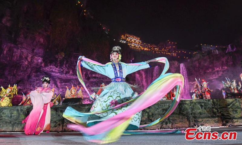 2021年3月31日拍摄的照片显示，中国戏曲表演者在中国中部湖南省芙蓉镇的舞台上挥舞着长袖。 周三晚上，一场国超表演在芙蓉镇开张。 非物质文化遗产的传承者与年轻的歌手和舞蹈演员一起表演，将传统非物质文化与现代艺术相结合，从而吸引了更多的年轻人来关注中国传统文化。 图片：中国新闻社