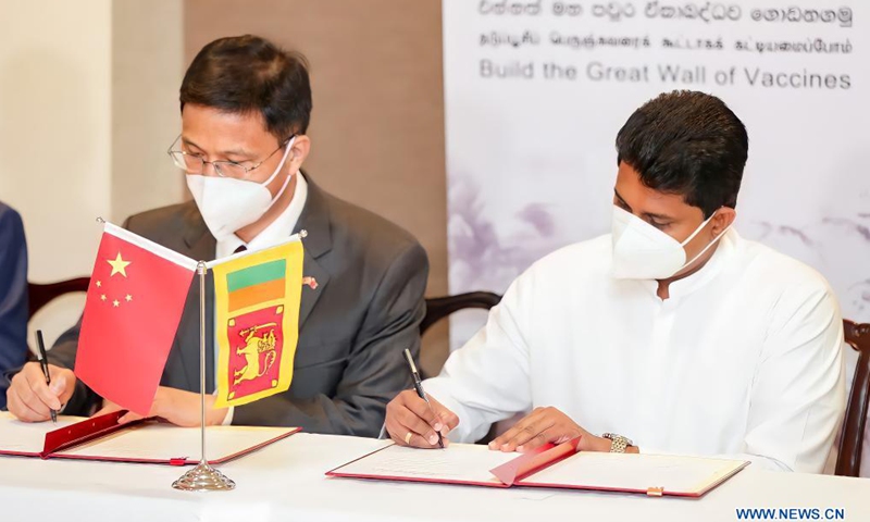 China's Ambassador to Sri Lanka Qi Zhenhong (L) and Sri Lanka's State Minister of Pharmaceutical Production, Supply and Regulation Channa Jayasumana attend an official certificate signing ceremony at the Bandaranaike International Airport in Colombo, Sri Lanka, March 31, 2021. A batch of Sinopharm vaccines arrived in Sri Lanka from China on Wednesday as part of a donation by the Chinese government to the island nation.Photo:Xinhua