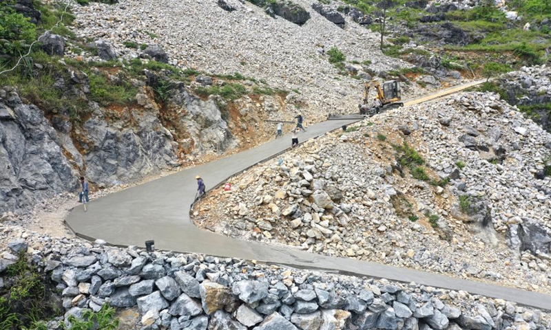 Aerial photo taken on May 13, 2020 shows people building the road access to Nonggentun of Nonghe Village in Dahua Yao Autonomous County, south China's Guangxi Zhuang Autonomous Region. Since 2016, Guangxi has promoted the construction and improvement of rural road network, with 52,900-kilometer roads built to link villages in rural areas.Photo:Xinhua