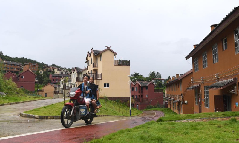 Villagers ride a motorcycle on the road of a resettlement area in Nandan County, south China's Guangxi Zhuang Autonomous Region, on Aug. 6, 2020. Since 2016, Guangxi has promoted the construction and improvement of rural road network, with 52,900-kilometer roads built to link villages in rural areas.Photo:Xinhua