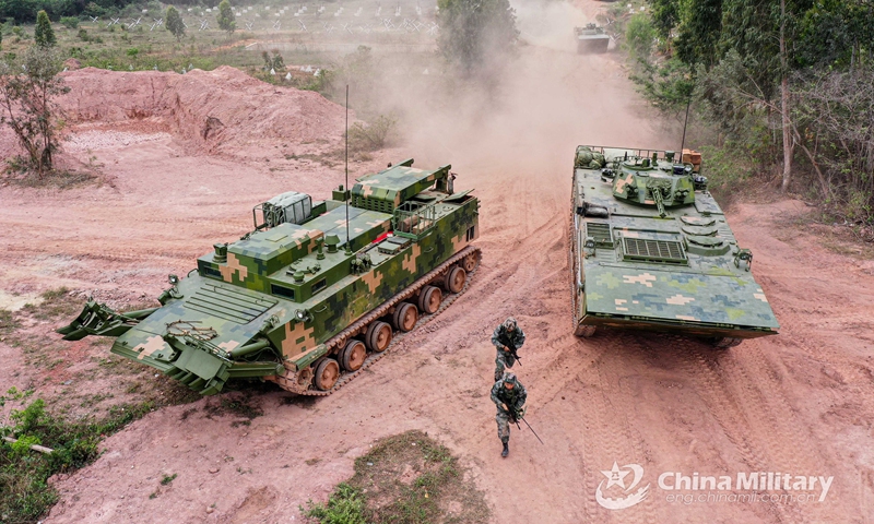 An engineering vehicle attached to an engineer element under the PLA 72nd Group Army carves out a way for troops during the breaching training in hilly area on March 22, 2021.Photo:China Military